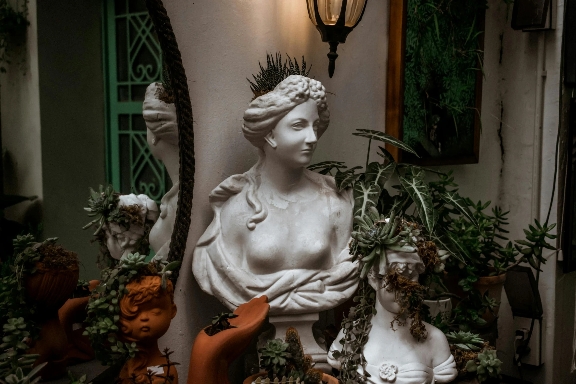 a statue sitting in the center of a room with plants on it