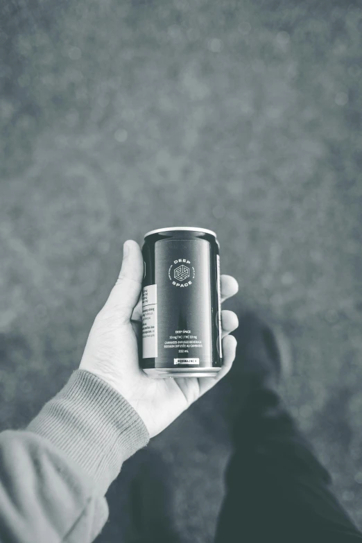 a hand holding a can of coffee in a black and white po