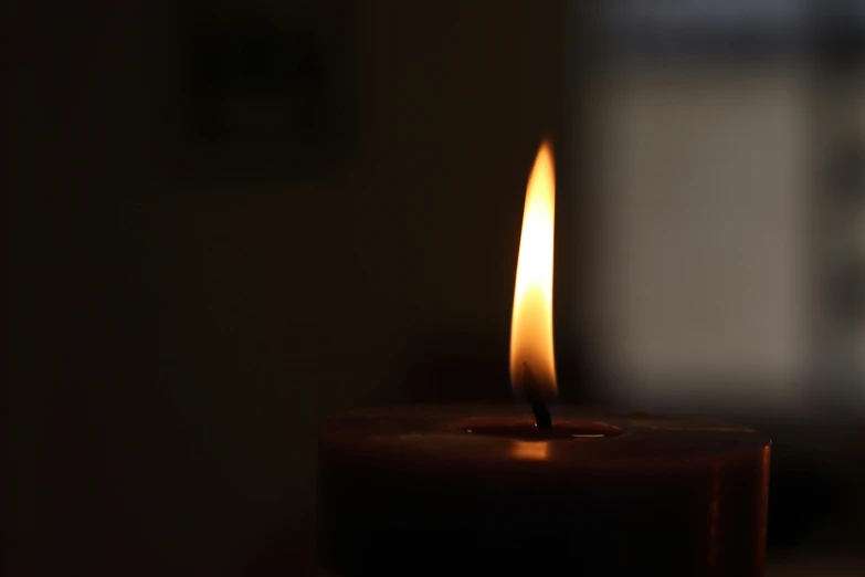 a lit candle sitting on top of a table