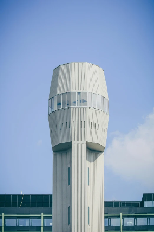 a very tall building with a spiraly building like structure behind it