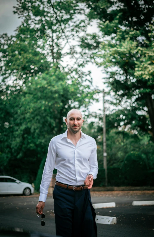 a man wearing a tie and shirt walks along the street