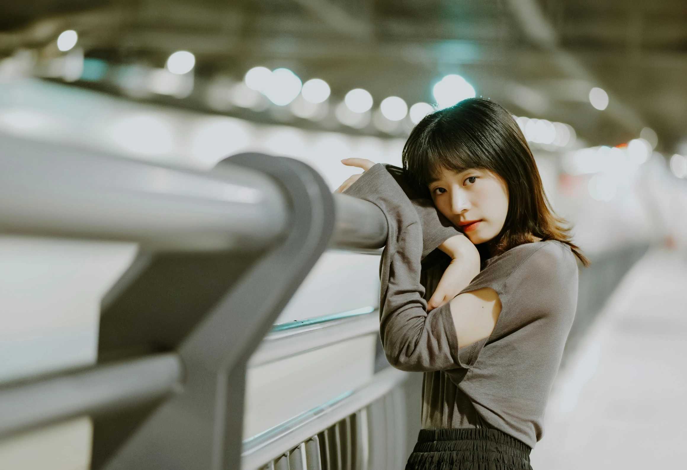 a woman leaning against a rail by her hands