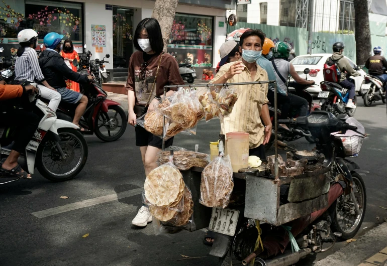 the women stand near two men on their bikes, wearing face masks