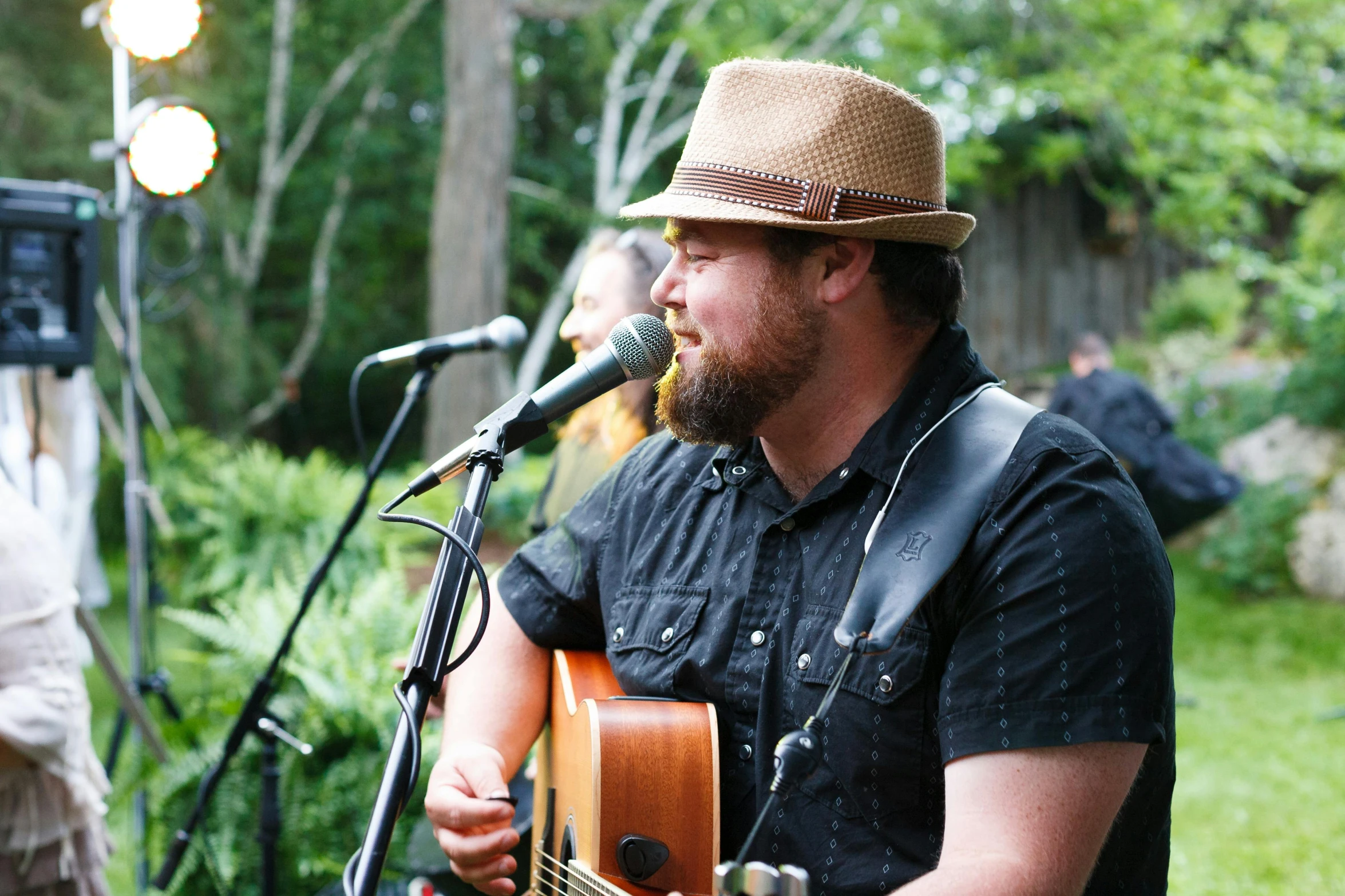 a man singing into a microphone while playing a guitar