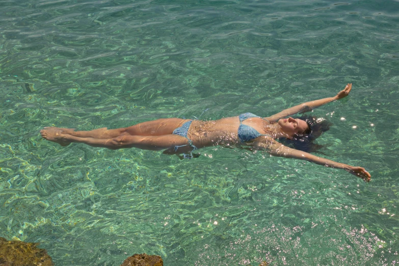 a woman laying on her side in the ocean