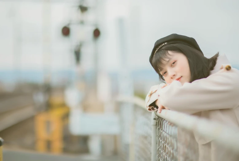 a woman is leaning on a railing overlooking the water