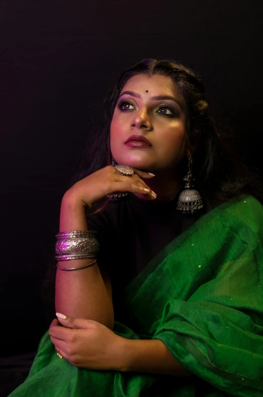 a woman is in green cloth with two celets on her neck