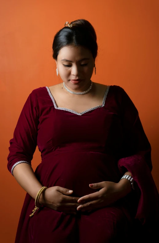 a woman in red dress is holding a piece of food