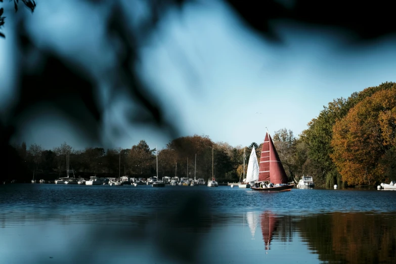 a sailboat sailing in the water next to houses