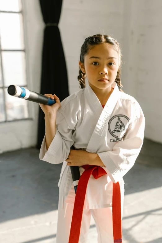 a girl stands and poses with her karate gear