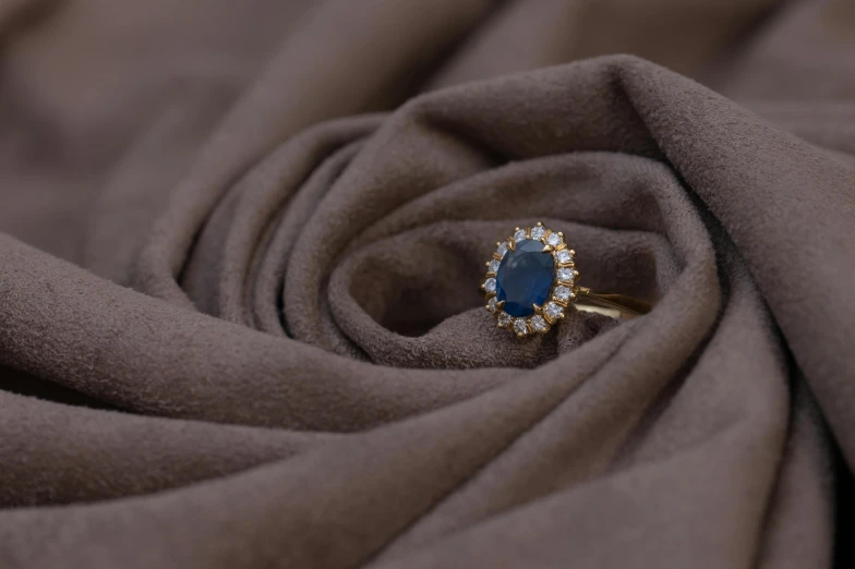 a blue ring sitting atop some brown fabric