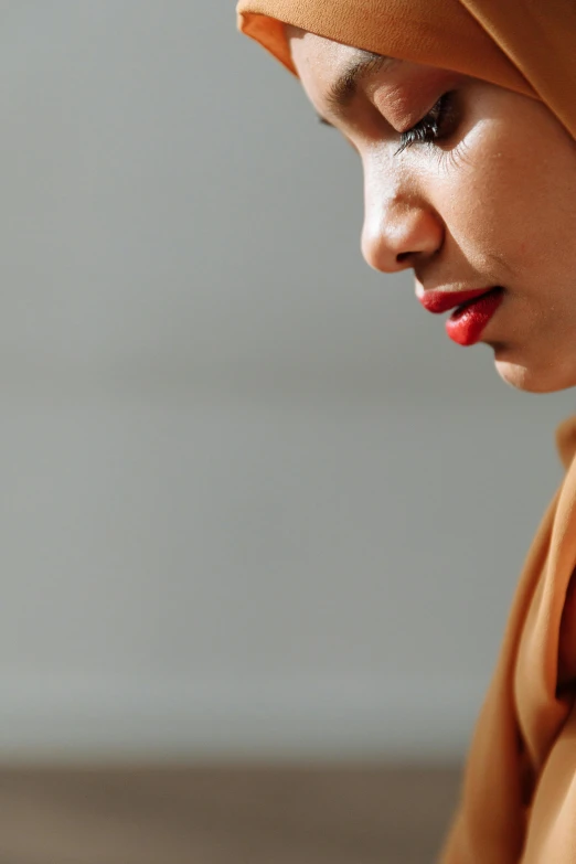 a woman wearing a hijab is holding a smart phone