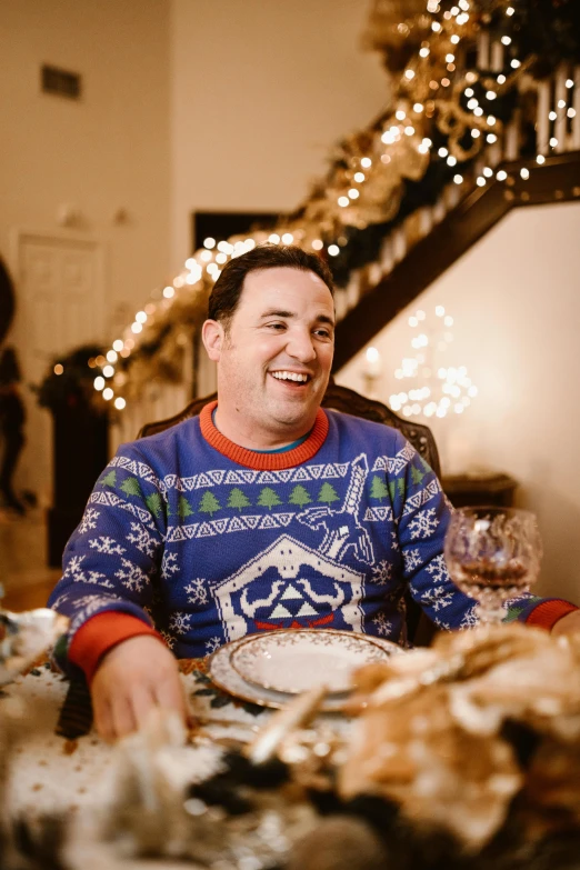 a man sitting at the table laughing for a camera