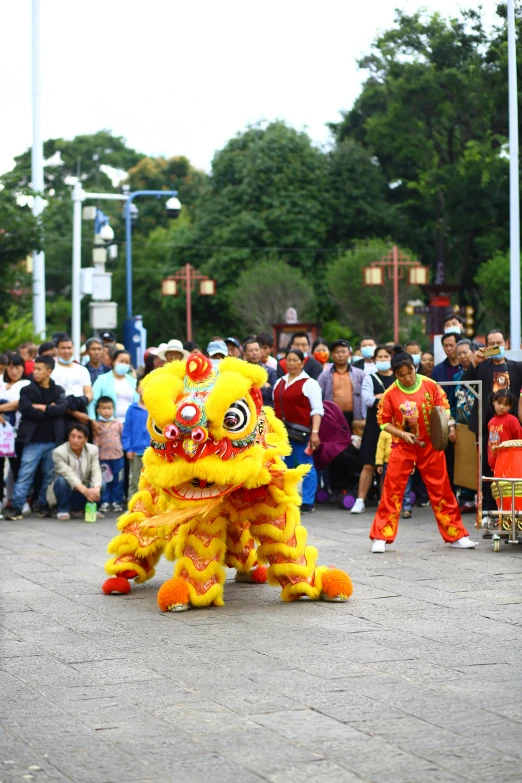 a parade with lion dancers in front of people watching