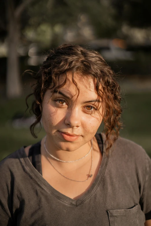 a woman wearing an old t - shirt is in the sun