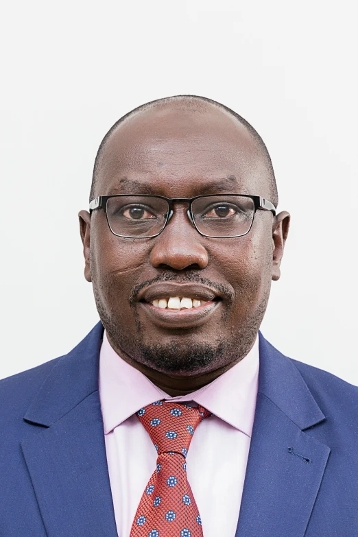 a man with glasses wearing a suit and tie