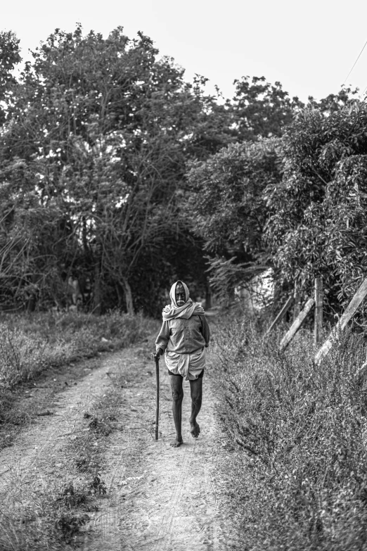 black and white pograph of woman walking along side of trail