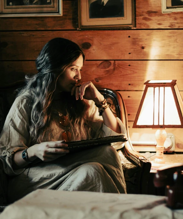 a woman sitting in a chair holding a light