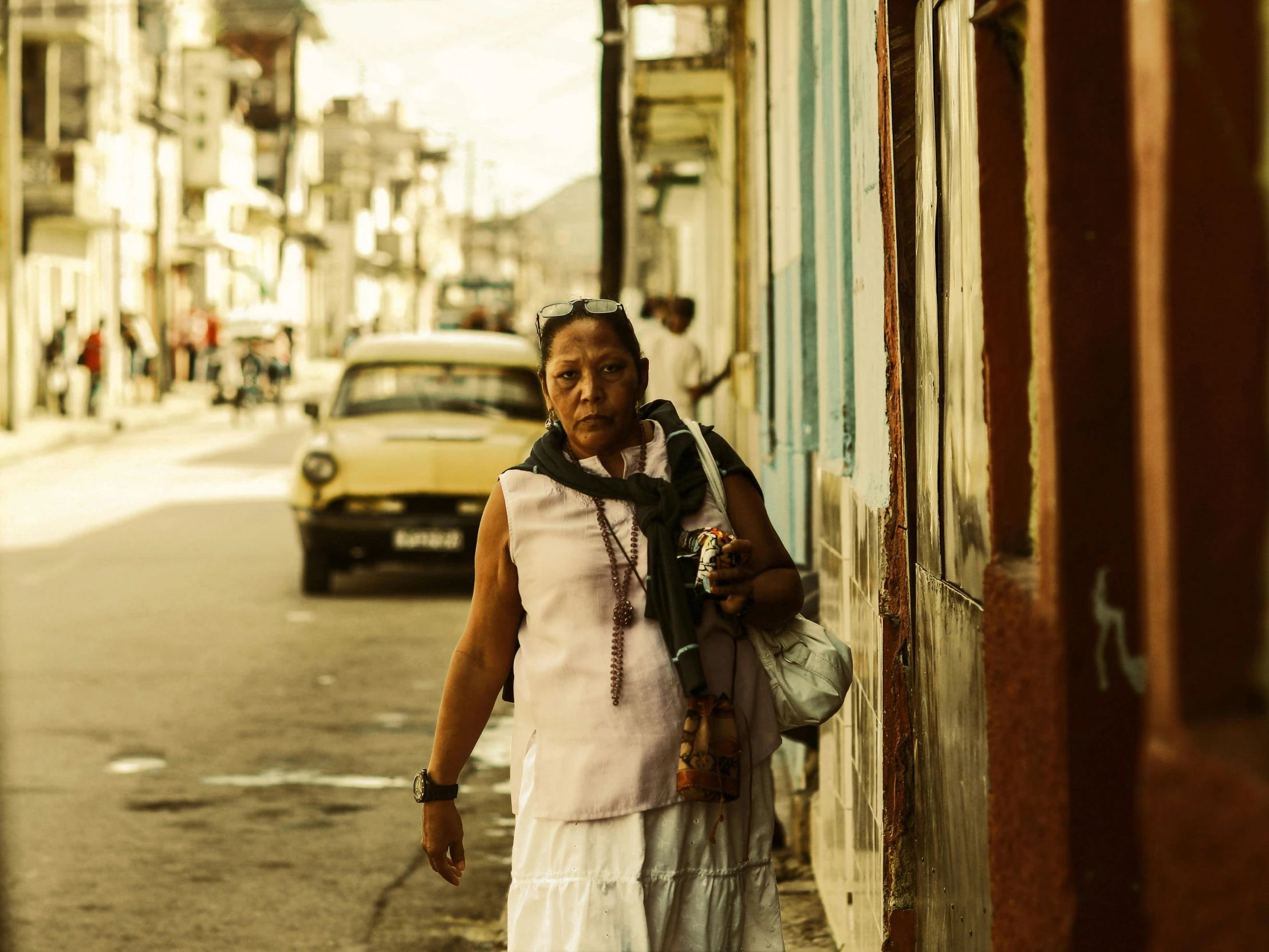 a woman is standing by the side of a building