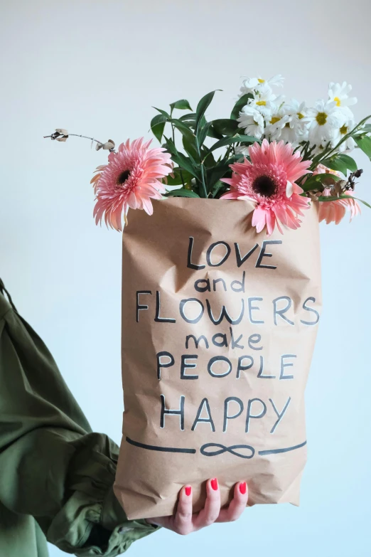 a brown paper bag with flowers inside of it