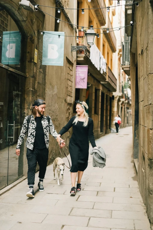 two people walk down an alley way holding hands