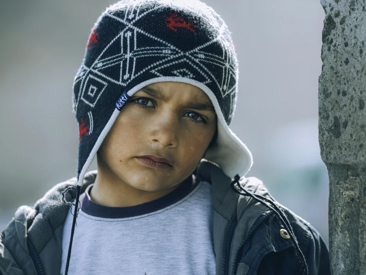 a close up of a child wearing a hat