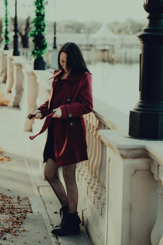 a woman is leaning on the side of a fence