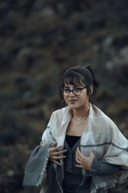 a woman wrapped up standing in the woods