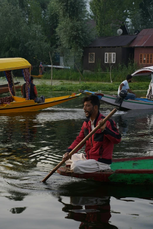 people in canoes on calm lake next to cabin