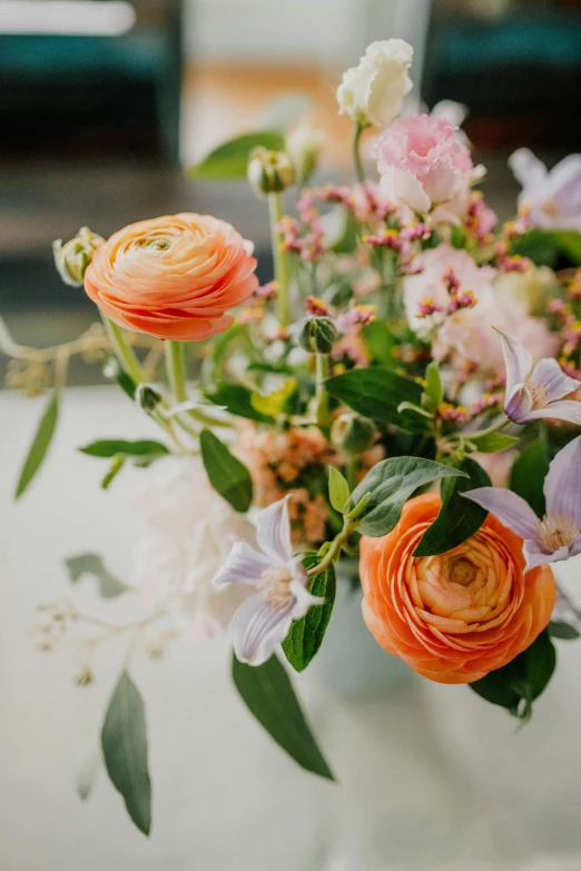 a white vase has many different colored flowers in it