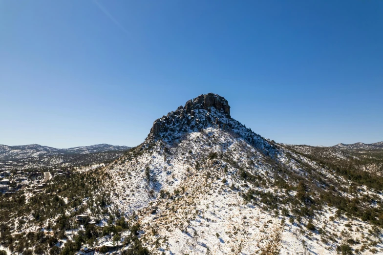 a snow covered peak with trees around it