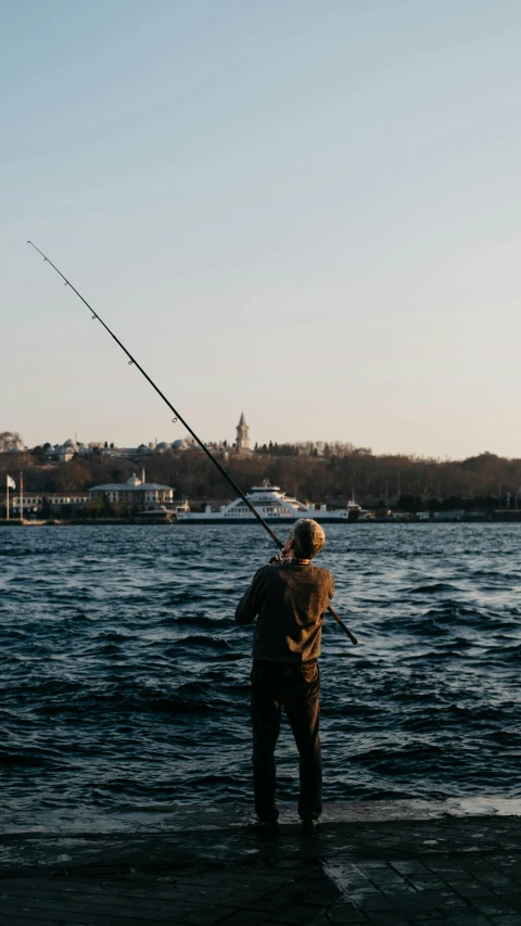 a man standing on the edge of a river fishing