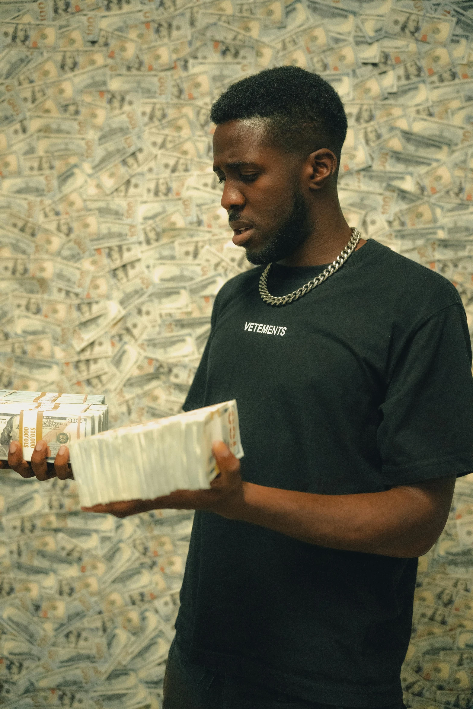 a man holding a pack of cigarettes near a wall