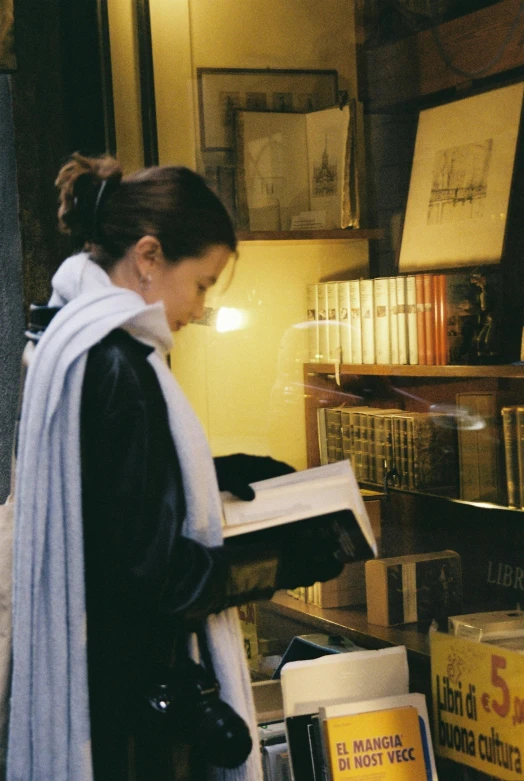 woman standing over a pile of books and reading