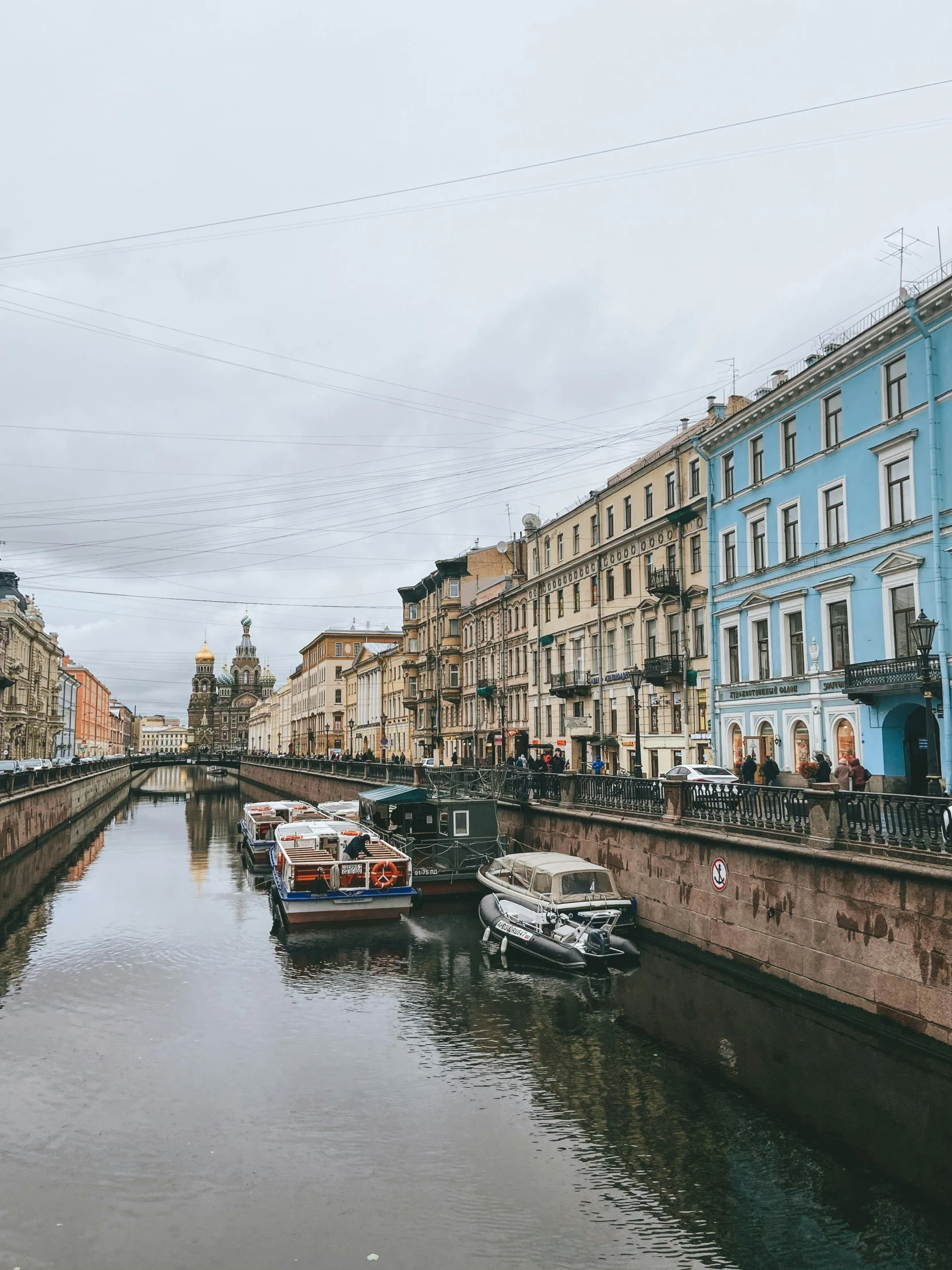 the boats are docked in a canal next to buildings