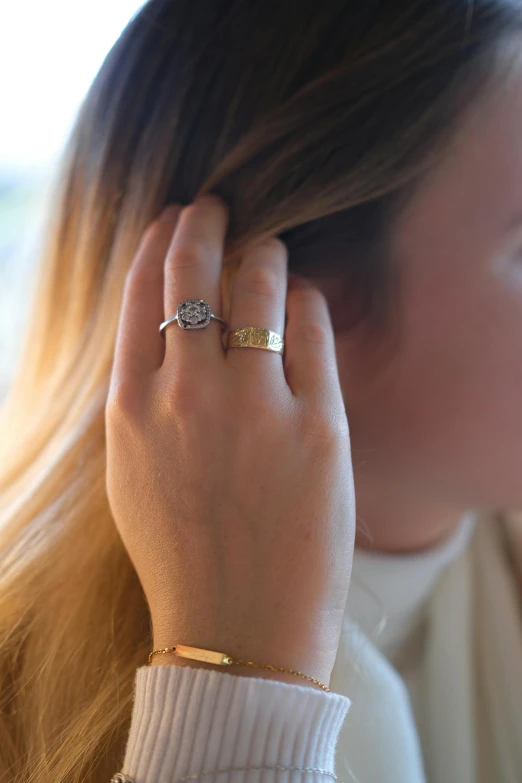 a woman is holding her hand up to her face