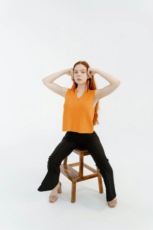 a woman sits in a chair and holds her head