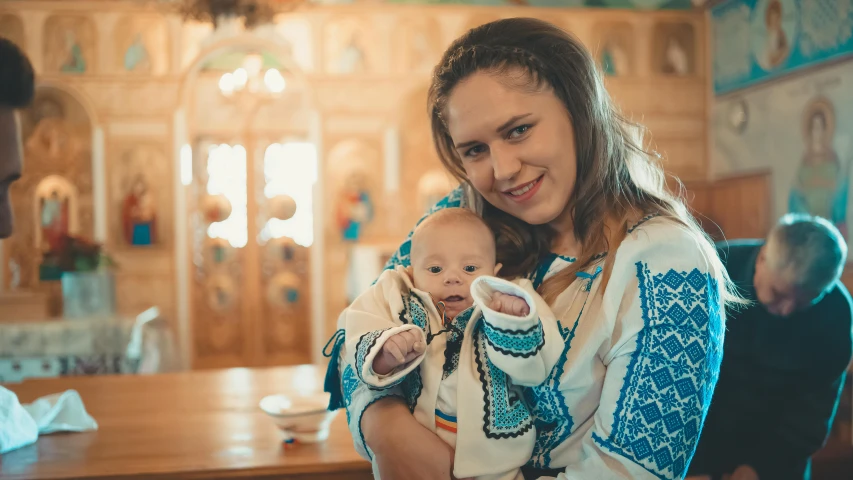 woman and child holding onto a remote control in their hands