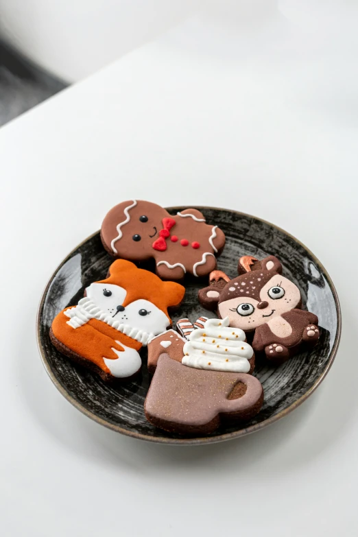 cookies on a plate decorated like bears and owls