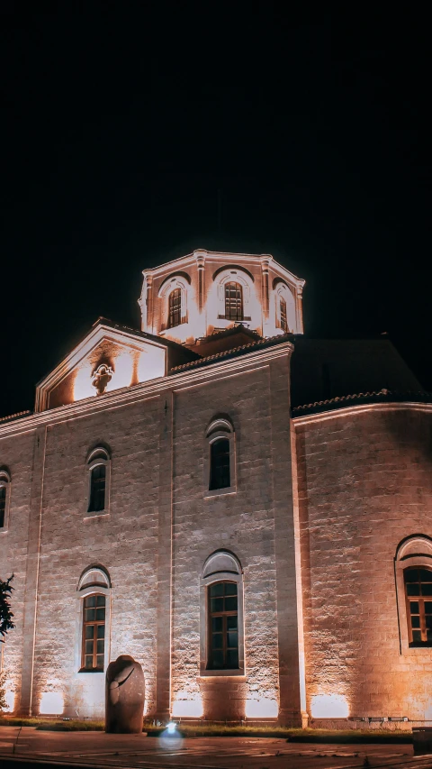 a very tall brick building with a steeple at night