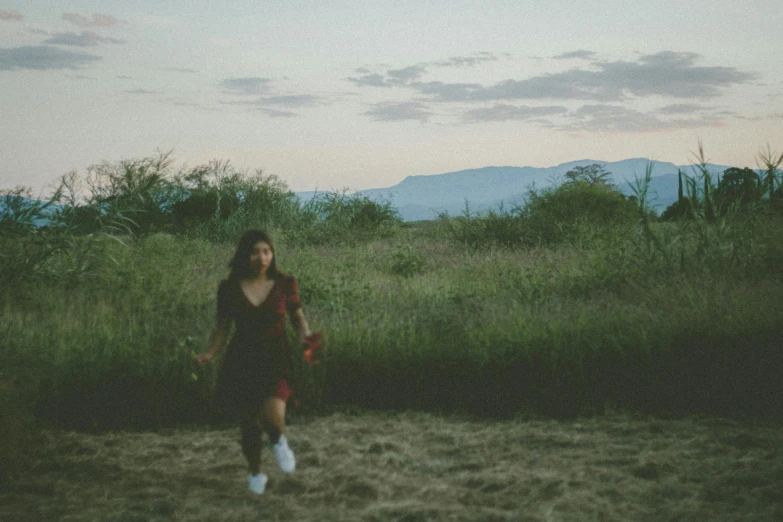 a girl in a field wearing sunglasses flying a kite