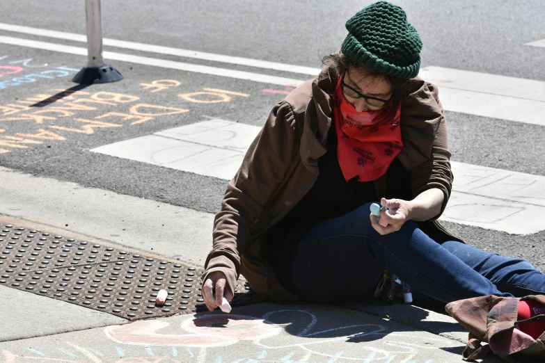 a woman sitting on the ground writing