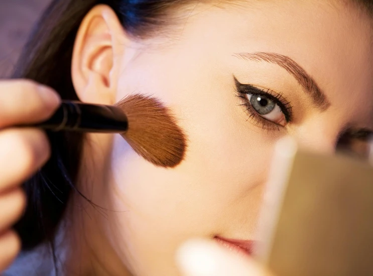 a woman doing makeup on her face