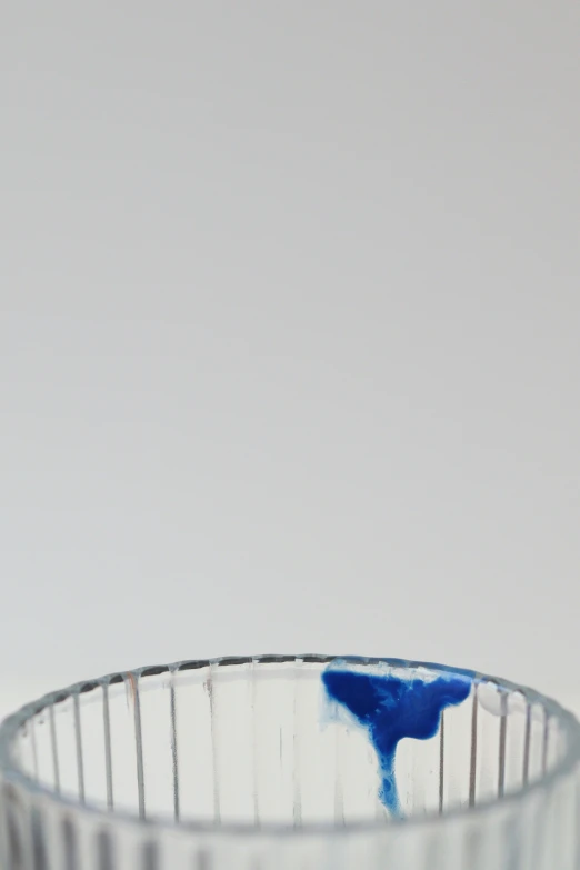 blue liquid pouring from a measuring glass on top of table