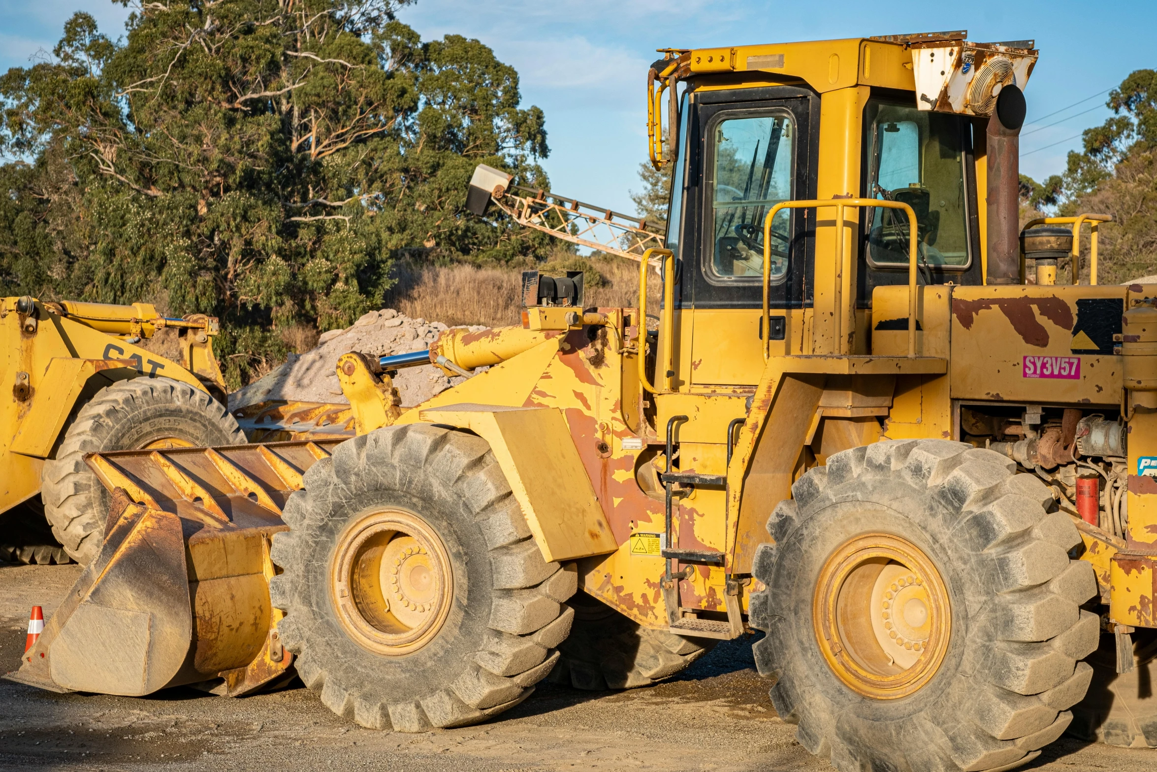 a yellow tractor sits on the ground in a pile