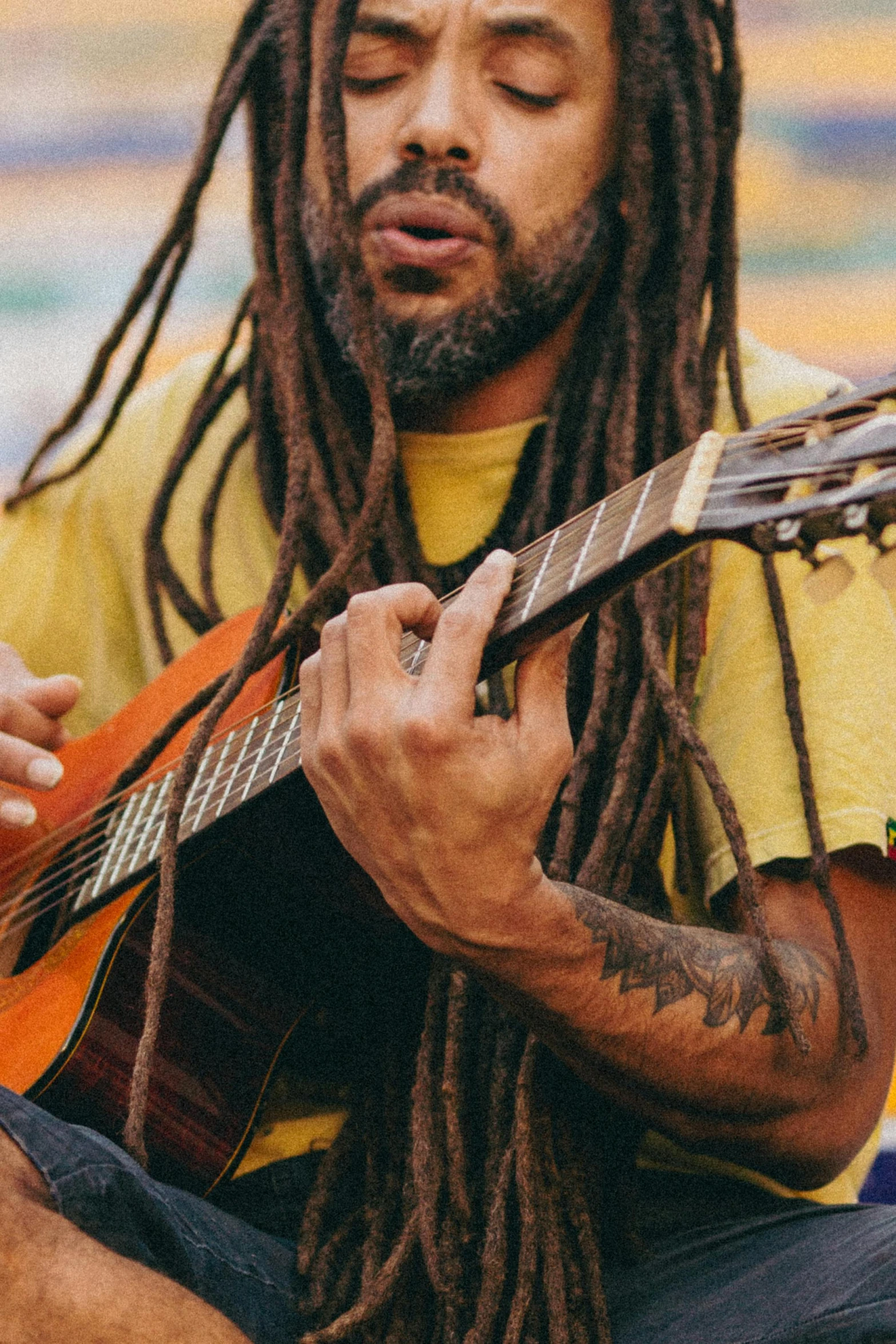 the man with dread locks is playing guitar