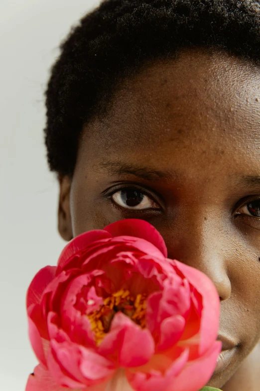 a girl smelling a flower in her hand