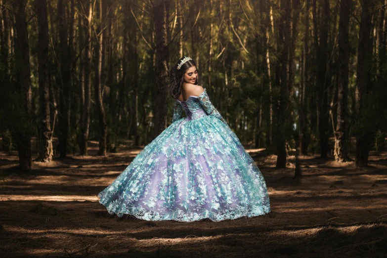 a woman in blue dress standing near trees