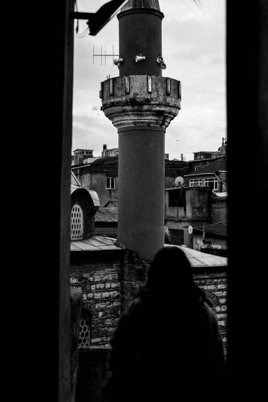 a black and white pograph of a person near a lighthouse