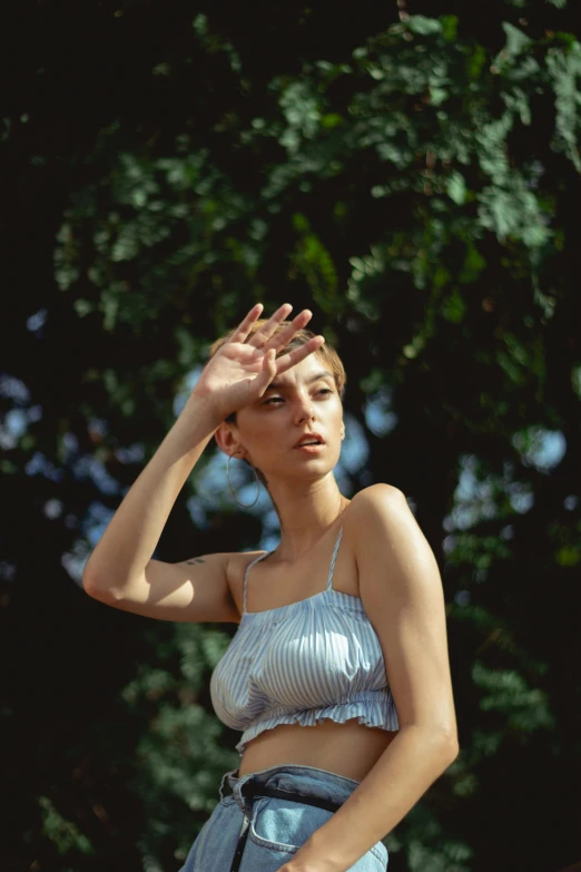 a woman with no underwear standing in front of some trees